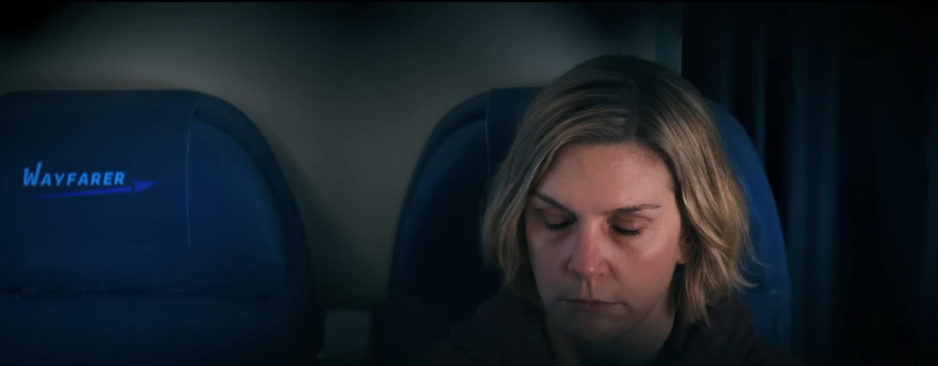 Rhea Seehorn in Pluribus, sitting on a Wayfrar plane.